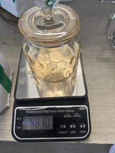 Dettaglio macro di barattolo in vetro ambrato su bilancia digitale con peso di 487 grammi