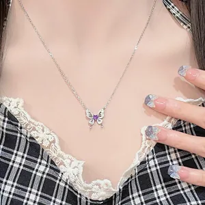 Detailed view of a silver butterfly necklace featuring a vibrant purple heart-shaped stone.
