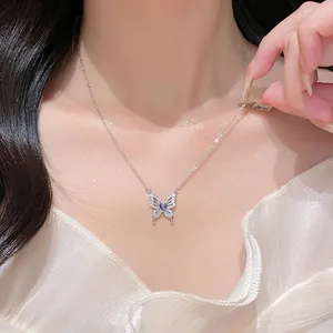 Detail shot of a silver butterfly necklace with purple gemstone on a model's neck