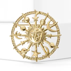 Gros plan d'une broche soleil en alliage doré avec des motifs d'étoiles et de lune