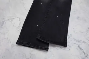 Détail rapproché d'un jean évasé noir pour homme avec un motif de taches de peinture