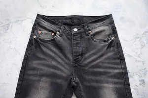 Gros plan d'un jean évasé noir ajusté pour homme avec une finition délavée classique en denim