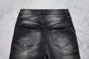 Vue détaillée des poches arrière et du délavage d'un jean évasé noir pour hommes