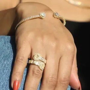 Close-up view of a heart-shaped zircon open ring and matching bangle worn on a model's hand