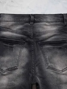 Détail du jean micro-flare pour hommes coupe ajustée en denim noir délavé style high street