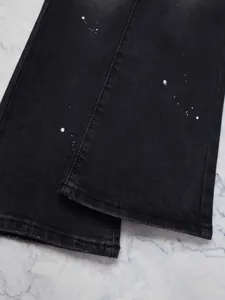 Jean évasé noir pour homme avec détails de taches de peinture blanche sur marbre