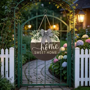 Wooden round door hanger featuring eucalyptus leaves and a striped bow on a garden gate