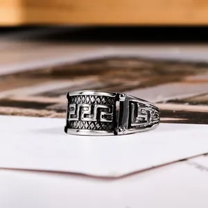 Retro titanium steel ring featuring classic Greek key meander pattern engraving detail.
