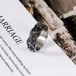 Vintage black titanium steel ring with embossed star patterns and wavy edges