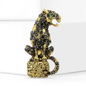 Close-up of a vintage gold leopard brooch with black rhinestones and a green eye