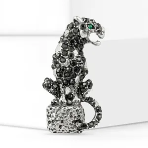 Close-up of vintage luxury leopard brooch with black rhinestones and green eyes
