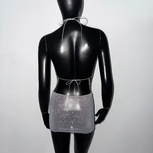 Vue arrière d'une mini-robe dos nu en résille à strass argentés avec lacets