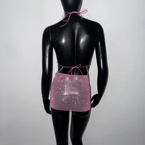 Vue arrière d'un ensemble mini-jupe et haut dos nu en résille rose à strass.