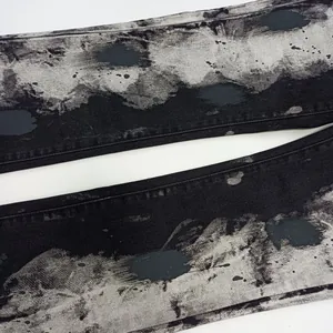 Dettaglio macro della stampa artistica inchiostro nero e grigio su denim premium