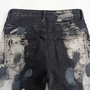 Primo piano delle tasche posteriori di jeans grigio neri con schizzi di vernice