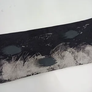 Macro vista del tessuto denim grigio nero con stampa astratta a macchie d'inchiostro