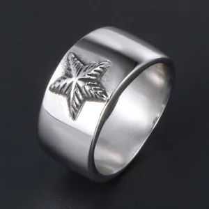 Bague large en acier titane argenté poli avec un motif d'étoile en relief texturé