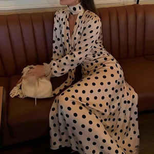 Vintage polka dot maxi dress with V-neck and decorative puff sleeves shown in a lifestyle setting