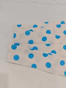 Macro detail of a beige sash belt featuring blue polka dot print on soft fabric