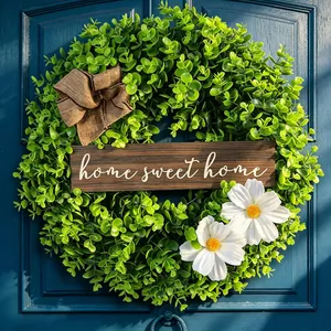 Artificial green wreath with Home Sweet Home sign and white daisies for front door