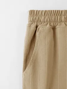 Gros plan sur la taille élastique et la poche d'un pantalon décontracté en lin rayé pour homme