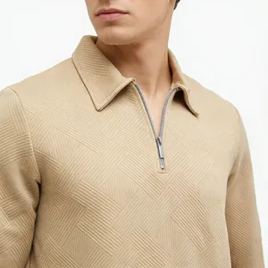 Detailed close-up view of beige textured jacquard long-sleeve polo shirt with zip