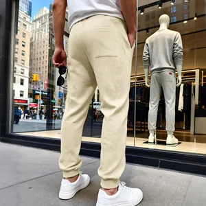 Πίσω όψη μπεζ ανδρικής φόρμας jogger με κλασικό ανάγλυφο σχέδιο ζακάρ και ελαστικά ρεβέρ