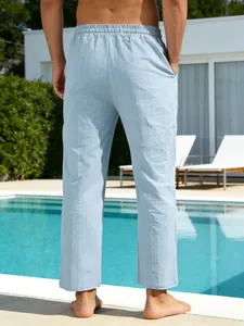 Vue arrière d'un pantalon décontracté en lin rayé bleu clair pour homme au bord d'une piscine