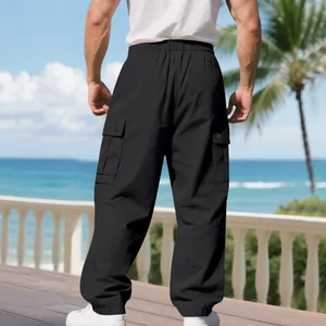 Detailed back view of men's black quick-dry cargo pants in a beach resort setting