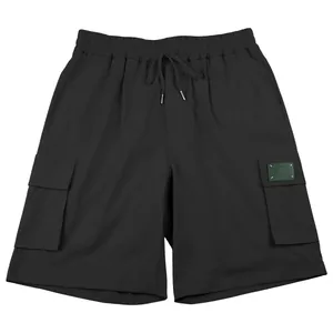 Close-up of black men's outdoor cargo shorts with side pockets and elastic drawstring waist