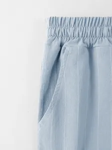 Détail du pantalon en lin rayé bleu clair avec taille élastique et texture de poche