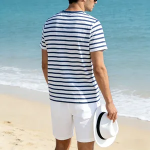 Back view of a man wearing a casual blue and white striped summer T-shirt on the beach