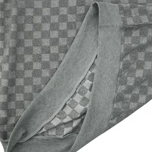 Close-up detail of the grey checkerboard jacquard knit fabric and ribbed hem texture