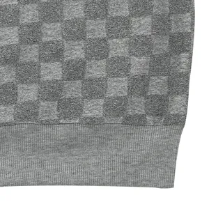 Macro detail of grey jacquard checkerboard texture on heavy knit sweater hem