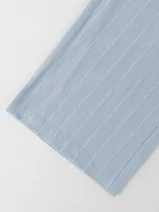 Vue détaillée en gros plan du tissu en lin à rayures bleu clair sur pantalon d'été