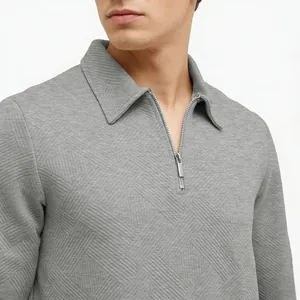 Detailed macro view of men's grey jacquard textured polo shirt featuring silver half-zip closure