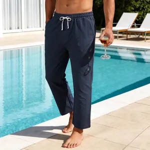 Détail d'un pantalon en lin à fines rayures bleu marine avec cordon blanc au bord