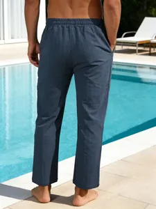Vue arrière d'un pantalon décontracté en lin rayé bleu pour homme au bord d'une piscine