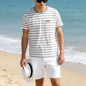 Outdoor beach lifestyle shot of a men's gray and white striped short sleeve T-shirt with pocket.