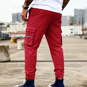 Dettaglio dei pantaloni cargo rossi da uomo con design multitasche e polsini alle caviglie