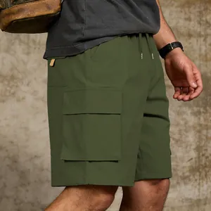 Detail view of army green men's cargo shorts with functional side flap pocket on model.