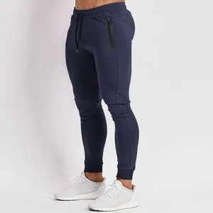 Side view showing slim-fit navy blue men's joggers featuring a waterproof zipper pocket