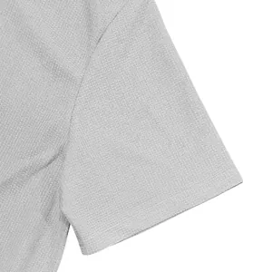 Macro view showing the intricate waffle knit texture of a light grey men's polo shirt sleeve