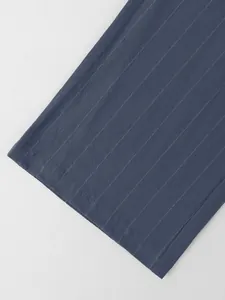 Détail du pantalon en lin à rayures bleues pour homme montrant la texture du tissu