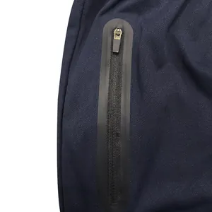 Close-up detail of waterproof zipper pocket on navy blue men's sports pants