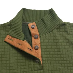 Detailaufnahme eines olivgrünen Sweatshirt-Kragens mit Waffelstrick und brauner Knopfleiste.