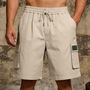 Detail view of khaki cargo shorts with elastic drawstring waist and side flap pockets