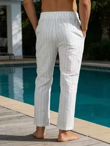 Détail vue arrière d'un pantalon décontracté en lin rayé blanc pour homme au bord de la piscine