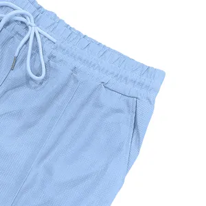 Detail macro view of light blue men's waffle knit shorts showing elastic drawstring waist