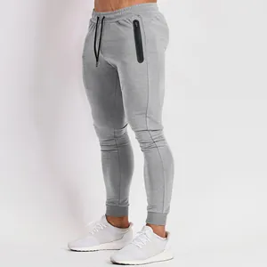 Detail view of men's gray joggers with black zipper pocket and slim fit design